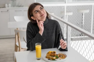 A woman practicing mindful eating while enjoying a homemade meal.